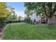 Lush backyard with a large lawn, mature trees, and a wooden fence at 3458 S Norfolk Way, Aurora, CO 80013