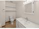 Updated bathroom features a vanity, toilet, shelves, and shower/bath combo at 3458 S Norfolk Way, Aurora, CO 80013