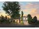 Charming two-story home with landscaped yard and mature trees against a dramatic sunset sky at 3458 S Norfolk Way, Aurora, CO 80013