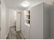 Hallway featuring gray tile flooring, storage cabinets, and access to a bathroom at 3458 S Norfolk Way, Aurora, CO 80013