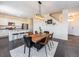 Dining room with a wood table, modern chandelier, and kitchen views at 6044 Point Rider Cir, Castle Rock, CO 80104