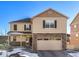 Two-story house with tan siding, stone accents, and a two-car garage at 6044 Point Rider Cir, Castle Rock, CO 80104