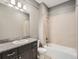 Bathroom features a vanity with granite countertop, toilet, and tiled shower and tub combo at 625 Kendall Way, Lakewood, CO 80214