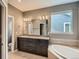 Bathroom featuring double vanity, granite counters, tub, and natural light at 625 Kendall Way, Lakewood, CO 80214