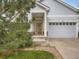 Inviting covered front porch, stone accents, and a two car garage, perfect for welcoming guests at 625 Kendall Way, Lakewood, CO 80214