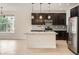 Bright kitchen featuring stainless steel appliances, dark cabinetry, an island and an eat-in area at 625 Kendall Way, Lakewood, CO 80214