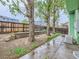 View of the fenced backyard with patio, landscaping, and mature trees providing shade at 12025 Monaco Dr, Brighton, CO 80602