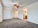 A bedroom with neutral walls and carpet; closet and bathroom visible from doorway at 12025 Monaco Dr, Brighton, CO 80602