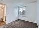 Bedroom with a window allowing natural light, and doorway to bathroom visible at 12025 Monaco Dr, Brighton, CO 80602