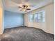 A carpeted room features a ceiling fan and windows that allow natural light into the room at 12025 Monaco Dr, Brighton, CO 80602