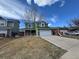 Inviting two-story green home with a two-car garage, driveway, and well-maintained lawn under a blue sky at 12025 Monaco Dr, Brighton, CO 80602