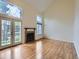 Bright living room featuring hardwood floors, a charming fireplace, large windows, and convenient glass doors at 12025 Monaco Dr, Brighton, CO 80602
