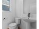 Modern half bathroom featuring a pedestal sink, toilet, and a clean white finish at 203 Washington St, Erie, CO 80516