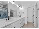 Modern bathroom featuring double vanity with marble countertop and black fixtures at 203 Washington St, Erie, CO 80516