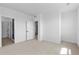 A cozy bedroom featuring neutral carpet, white walls, and doorways to additional rooms at 203 Washington St, Erie, CO 80516