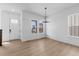 A bright dining area featuring light hardwood floors, white walls, and a modern chandelier at 203 Washington St, Erie, CO 80516