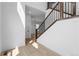 A modern entryway featuring hardwood floors, white walls, and dark wood trim and staircase at 203 Washington St, Erie, CO 80516