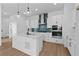 Modern white kitchen with stainless steel appliances, a blue backsplash, and a large island at 203 Washington St, Erie, CO 80516