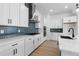 Close-up of kitchen featuring custom cabinets, a stainless steel range hood, and a blue backsplash at 203 Washington St, Erie, CO 80516