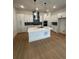 Modern kitchen featuring a large island, white cabinetry, and stainless steel appliances at 203 Washington St, Erie, CO 80516