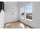Bright, airy living space featuring light hardwood floors, crisp white walls, and abundant natural light from large windows at 203 Washington St, Erie, CO 80516