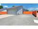 Rear view of home with a two-car garage and a large driveway with orange fence to create privacy at 2800 Troxell Ave, Longmont, CO 80503