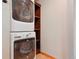 Stackable white washer and dryer, next to wooden shelving for convenient laundry storage at 2800 Troxell Ave, Longmont, CO 80503