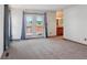 Bright living room featuring a door to an outdoor deck, carpeted floors and an entry to the bathroom at 2800 Troxell Ave, Longmont, CO 80503