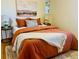 Bedroom with burnt orange bedding, end tables, and artwork at 799 N Holly St, Denver, CO 80220
