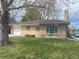Charming brick home featuring a well-manicured lawn and attached garage, perfect for suburban living at 799 N Holly St, Denver, CO 80220