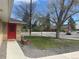 Street view of brick home showcasing the red front door and well-maintained lawn at 799 N Holly St, Denver, CO 80220