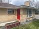 Attractive brick house featuring a vibrant red front door and manicured landscaping at 799 N Holly St, Denver, CO 80220