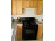This kitchen showcases granite countertops, wood cabinets and a black gas range at 799 N Holly St, Denver, CO 80220