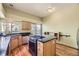 Modern kitchen island with cooktop, granite countertop, stainless steel appliances, and ample natural light at 9742 E Hawaii Pl, Aurora, CO 80247