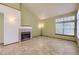 Bright living room features a fireplace, tile flooring, and a large window, offering a comfortable and inviting space at 9742 E Hawaii Pl, Aurora, CO 80247
