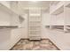 Walk-in closet features built-in shelving and ceramic tile flooring at 9742 E Hawaii Pl, Aurora, CO 80247