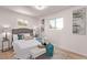 Bright bedroom with a cushioned bench at the end of the bed, two windows and new floors at 9120 Judson St, Westminster, CO 80031