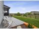 Backyard with green lawn, a concrete patio, Adirondack chairs, and wood fence at 359 Rogers Way, Castle Rock, CO 80104