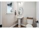 Cozy half-bathroom featuring a pedestal sink, stylish mirror, and tile flooring at 359 Rogers Way, Castle Rock, CO 80104