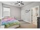 Bright bedroom featuring a ceiling fan, window, carpet, and door to bathroom at 359 Rogers Way, Castle Rock, CO 80104