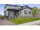 The home's exterior is enhanced by a covered porch, beautiful stonework, lush lawn, and landscaped yard at 359 Rogers Way, Castle Rock, CO 80104