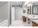 Bright bathroom featuring double sinks, wood cabinets, and large mirrors at 1521 Vine St # 108, Denver, CO 80206