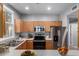 Bright kitchen with stainless steel appliances and wooden cabinets, virtually staged at 1521 Vine St # 108, Denver, CO 80206