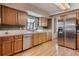 Well-lit kitchen features stainless appliances, wood cabinets, and a window over the sink at 2912 Lake Park Way, Longmont, CO 80503
