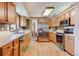 Bright kitchen boasts stainless appliances, wood cabinets, and light hardwood floors at 2912 Lake Park Way, Longmont, CO 80503