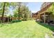 Lush backyard featuring a well-manicured lawn, mature trees, and a multi-tiered deck at 5557 E Links Cir, Centennial, CO 80122