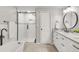 Modern bathroom featuring a walk-in shower, soaking tub, white vanity, and black hardware at 5557 E Links Cir, Centennial, CO 80122
