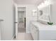 Well-lit bathroom with a double sink vanity, modern lighting, and an open doorway at 5557 E Links Cir, Centennial, CO 80122