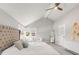 Bright bedroom with vaulted ceilings and seating area by windows at 5557 E Links Cir, Centennial, CO 80122
