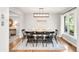 Bright dining room boasts a modern light fixture, a cozy seating bench, and a large sun-filled window at 5557 E Links Cir, Centennial, CO 80122
